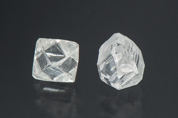 On left is an octahedral natural diamond crystal. On right is an HPHT laboratory-grown diamond crystal.